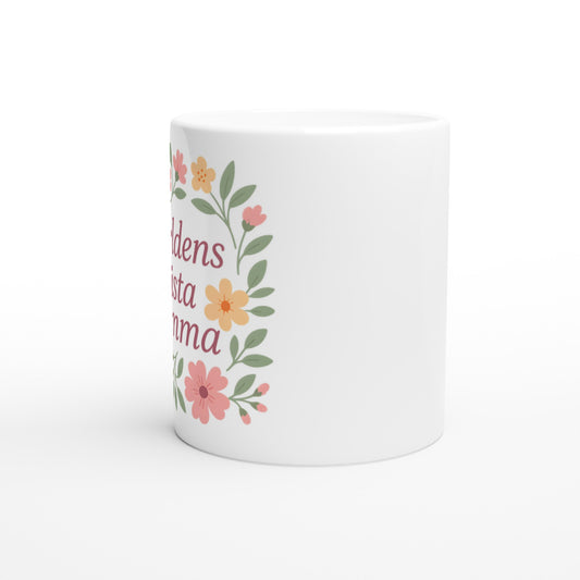 Mugg med texten Världens bästa mamma omgiven av mjuka blommor och blad i pastellfärger.