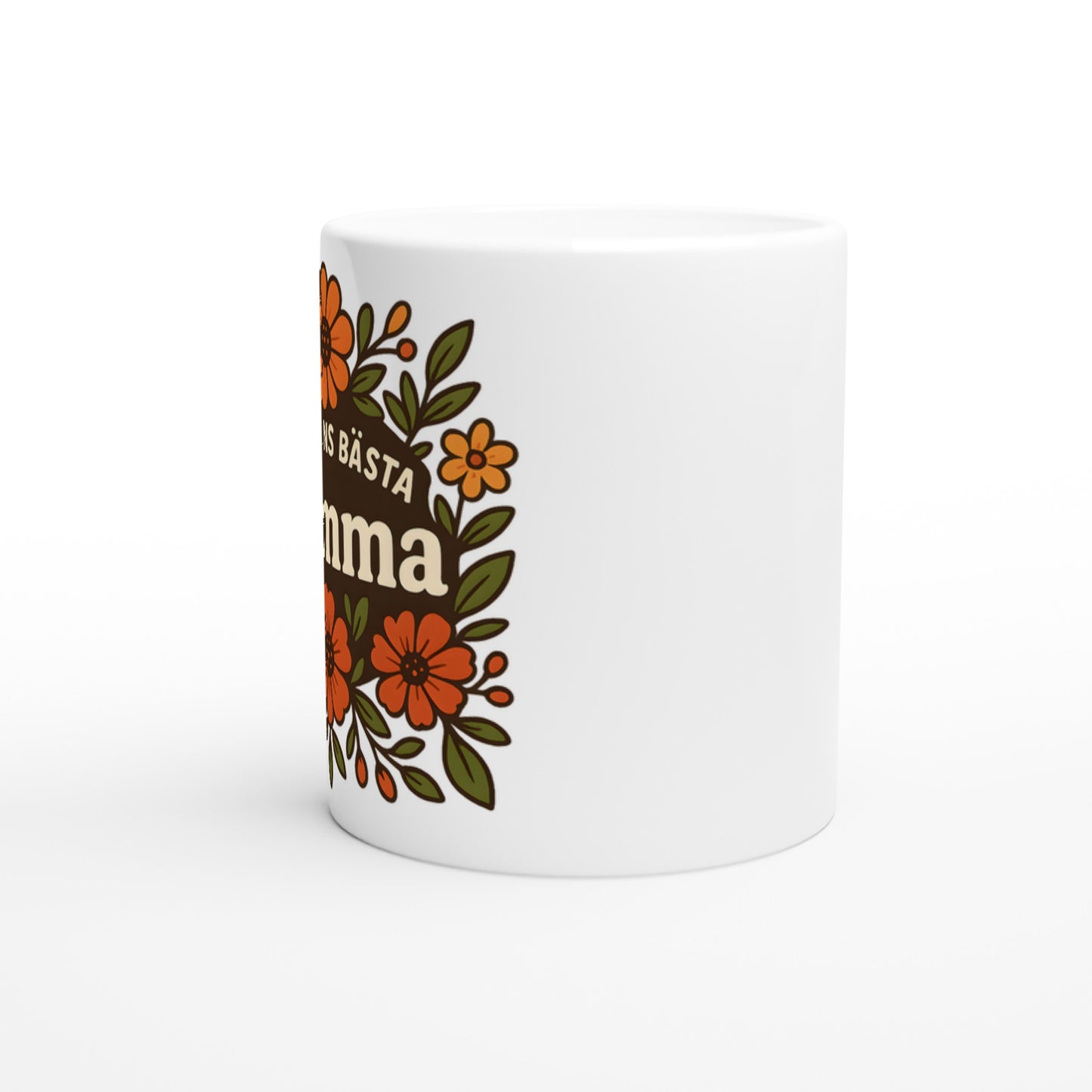 Mugg med blomstrande mönster och texten 'Världens bästa mamma' i fokus, omgiven av varma blommor. För att hedra mamman.