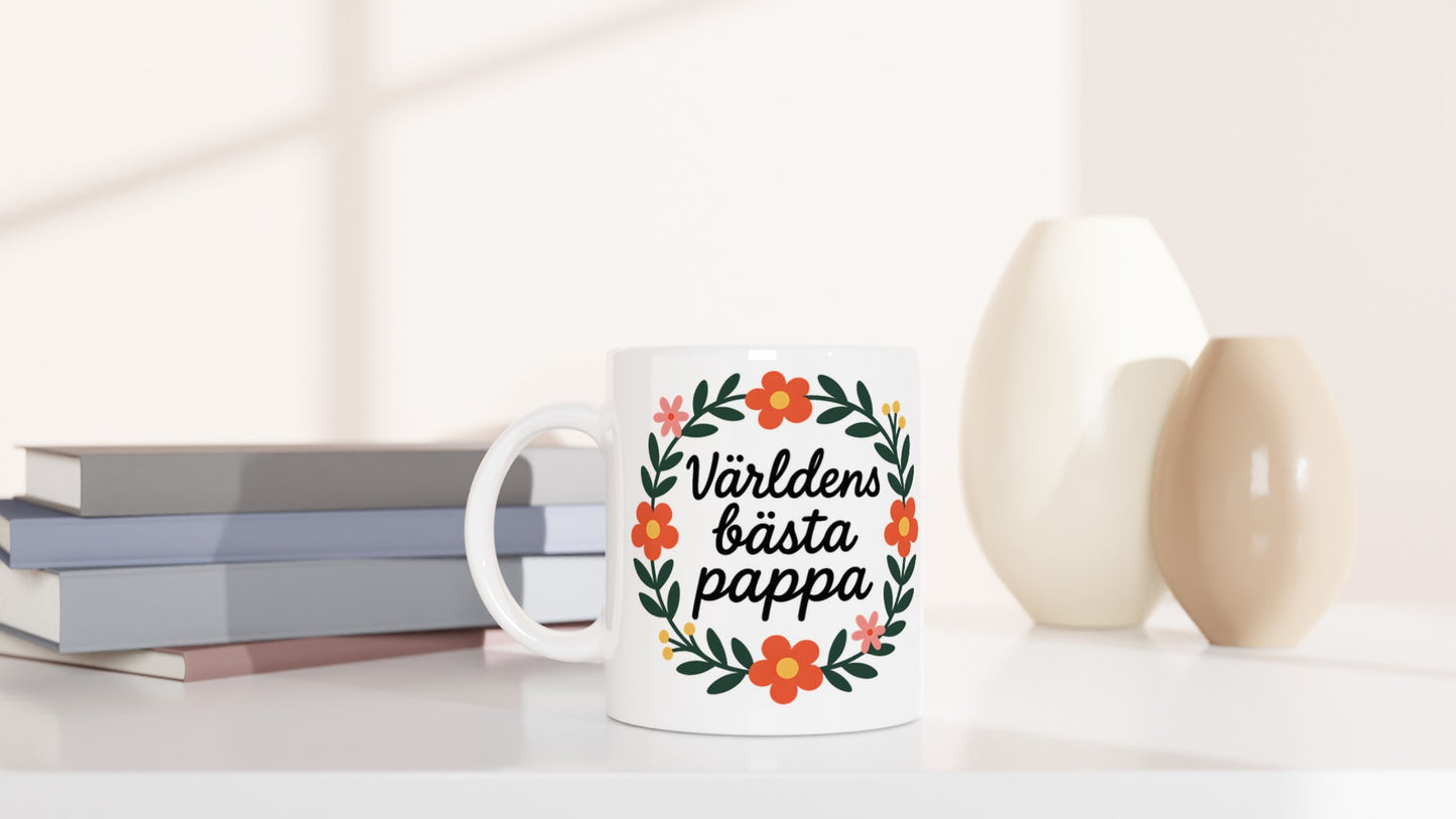 Mugg med texten 'Världens bästa pappa' i blomsterkrans, handskriven stil. Visa uppskattning.