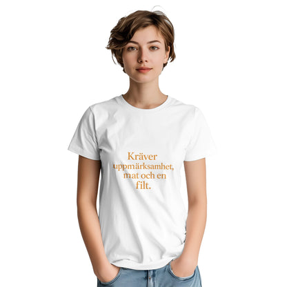 T-shirt med rolig och varm statement-text för henne. Kräver uppmärksamhet, mat och en filt. Chic font och tonad färg.