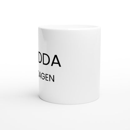 Mugg med texten Krydda Vardagen på en vit bakgrund med en kryddburk och en sked bredvid.