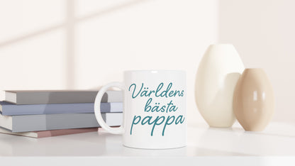 Mugg med texten 'Världens bästa pappa' i elegant handskriven font och varm blågrön färg. Perfekt till fars dag eller som uppskattning.