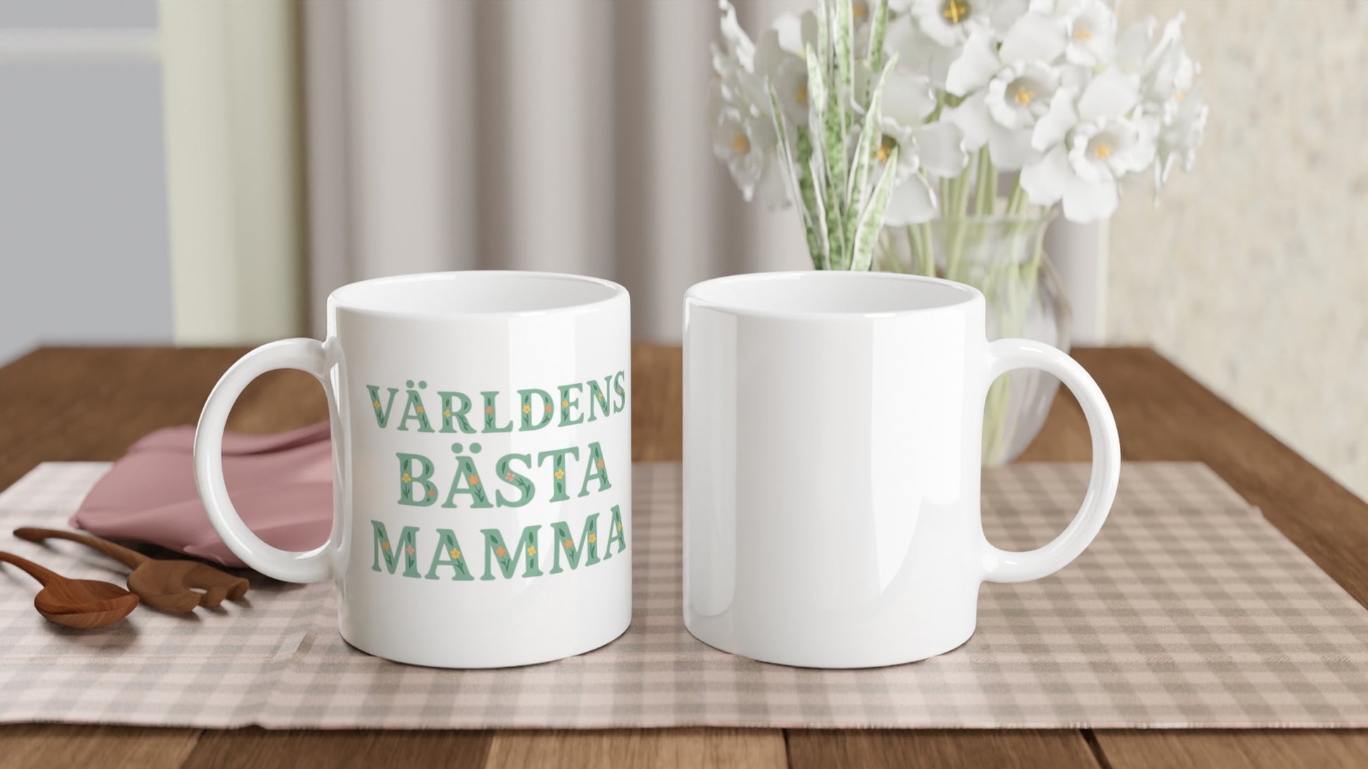 Mugg med blommigt mönster och texten 'Världens bästa mamma' i mjuk grön färg. Perfekt present till mamma.
