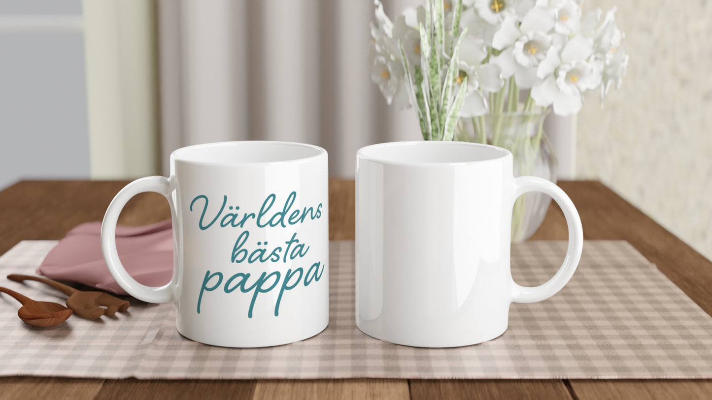 Mugg med texten 'Världens bästa pappa' i elegant handskriven font och varm blågrön färg. Perfekt till fars dag eller som uppskattning.