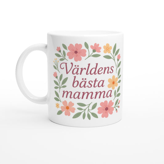Mugg med texten Världens bästa mamma omgiven av mjuka blommor och blad i pastellfärger.