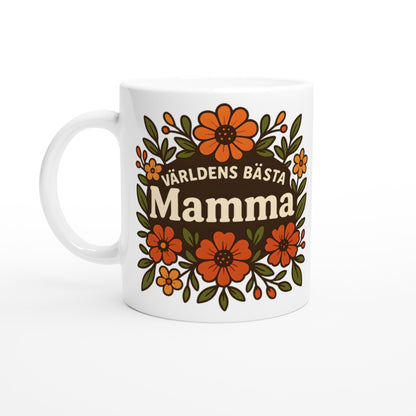 Mugg med blomstrande mönster och texten 'Världens bästa mamma' i fokus, omgiven av varma blommor. För att hedra mamman.