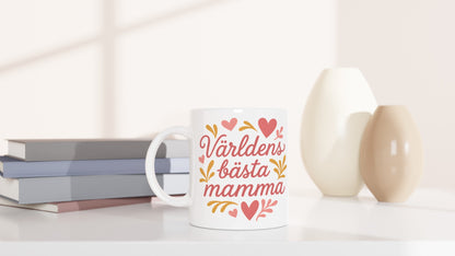 Mugg med texten 'Världens bästa mamma' i romantisk stil, dekorerad med hjärtan och former.